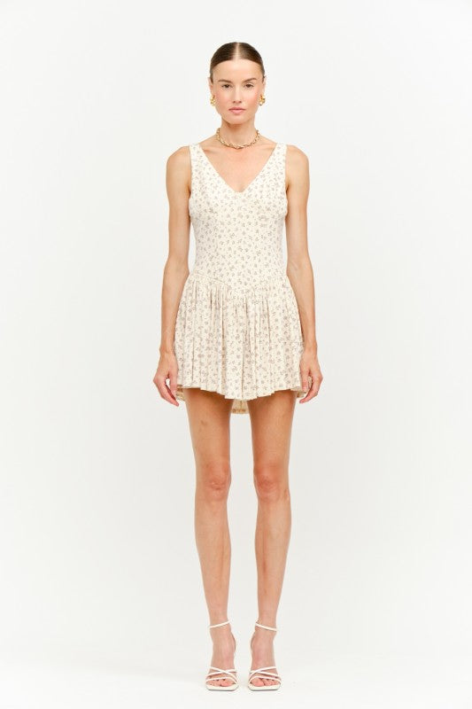 Floral print sleeveless dress in beige, featuring a V-neck and a flared skirt for a feminine look.