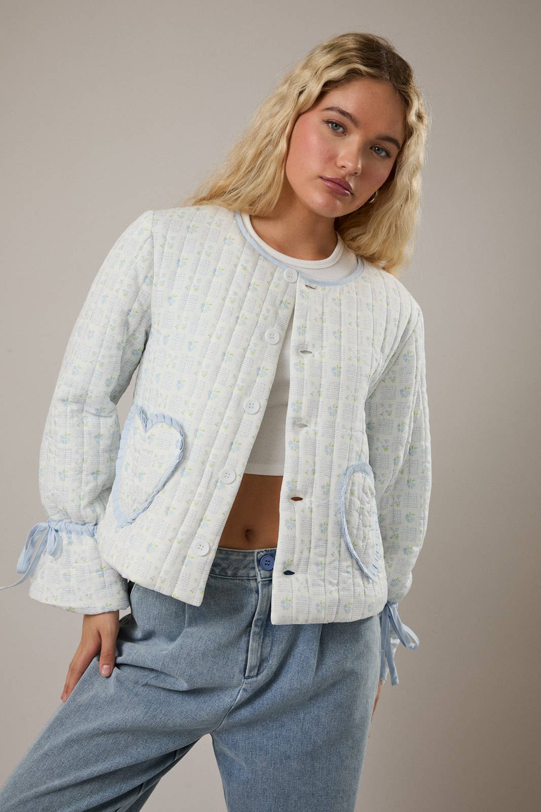 Quilted light blue women's cardigan with heart pockets and ribbon details, perfect for cool weather.
