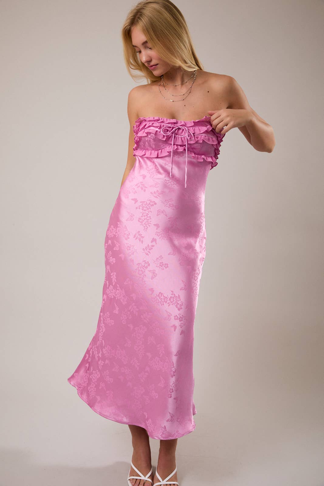 Strapless pink satin dress with ruffled neckline and floral pattern, perfect for summer events.