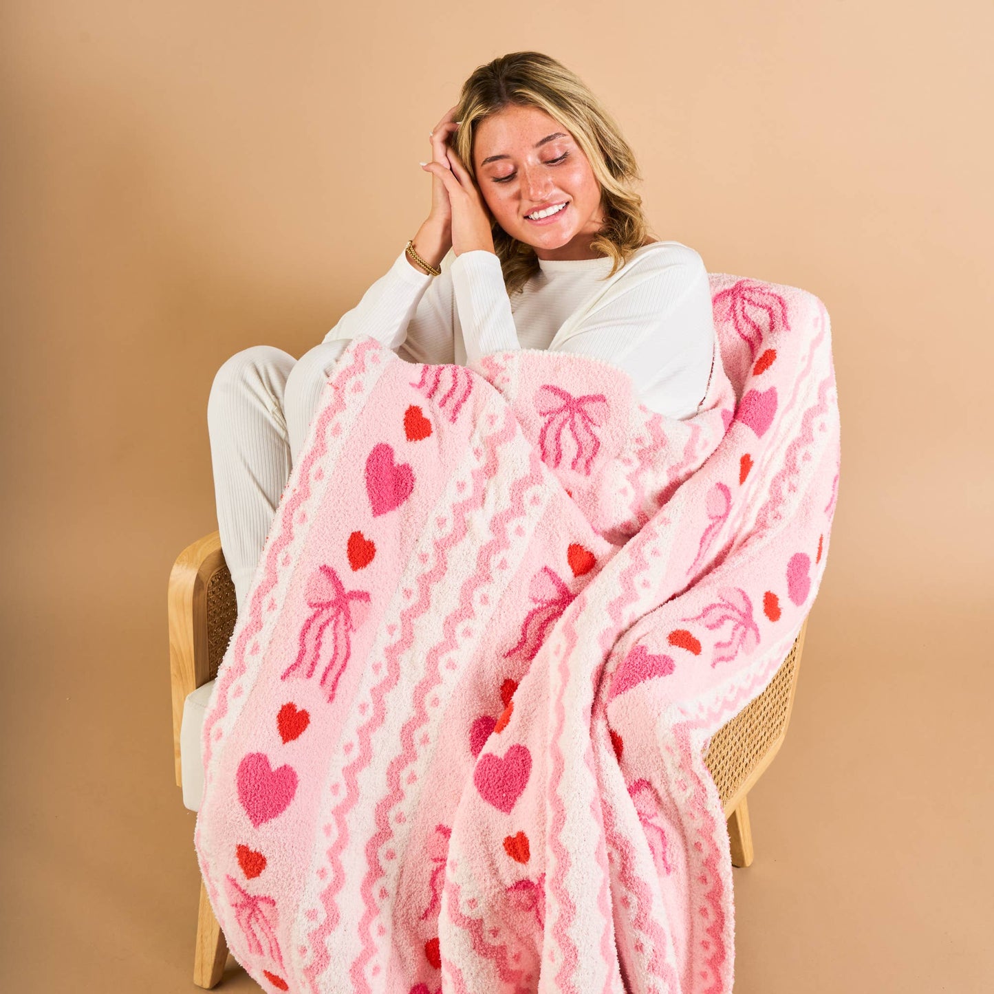 Cozy pink blanket with heart patterns, perfect for adding warmth and style to any space.