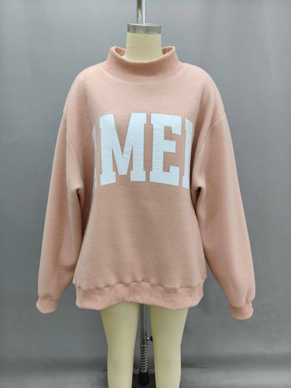Oversized pink sweatshirt with white lettering, made from soft fleece material, featuring a cozy high collar.