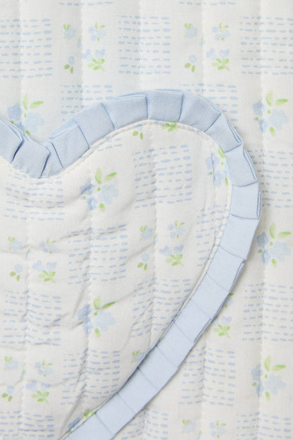 Light blue floral quilted bedding with heart-shaped pattern and ruffled trim for a cozy bedroom decor.