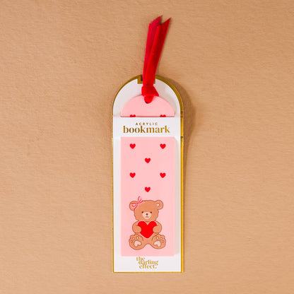 Acrylic bookmark featuring a cute bear with a heart, pink background, and red ribbon detail.