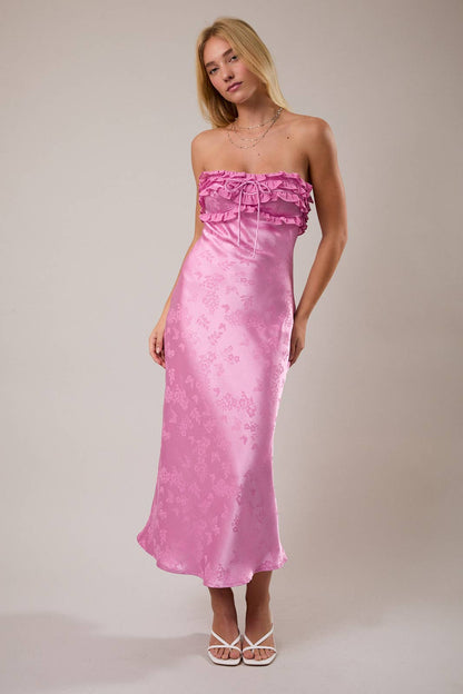 Stylish pink satin maxi dress with ruffled strap design and floral details, perfect for summer occasions.