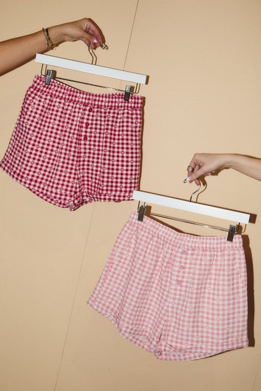 Comfortable cotton gingham sleep shorts in red and pink, featuring a button front and elastic waistband.