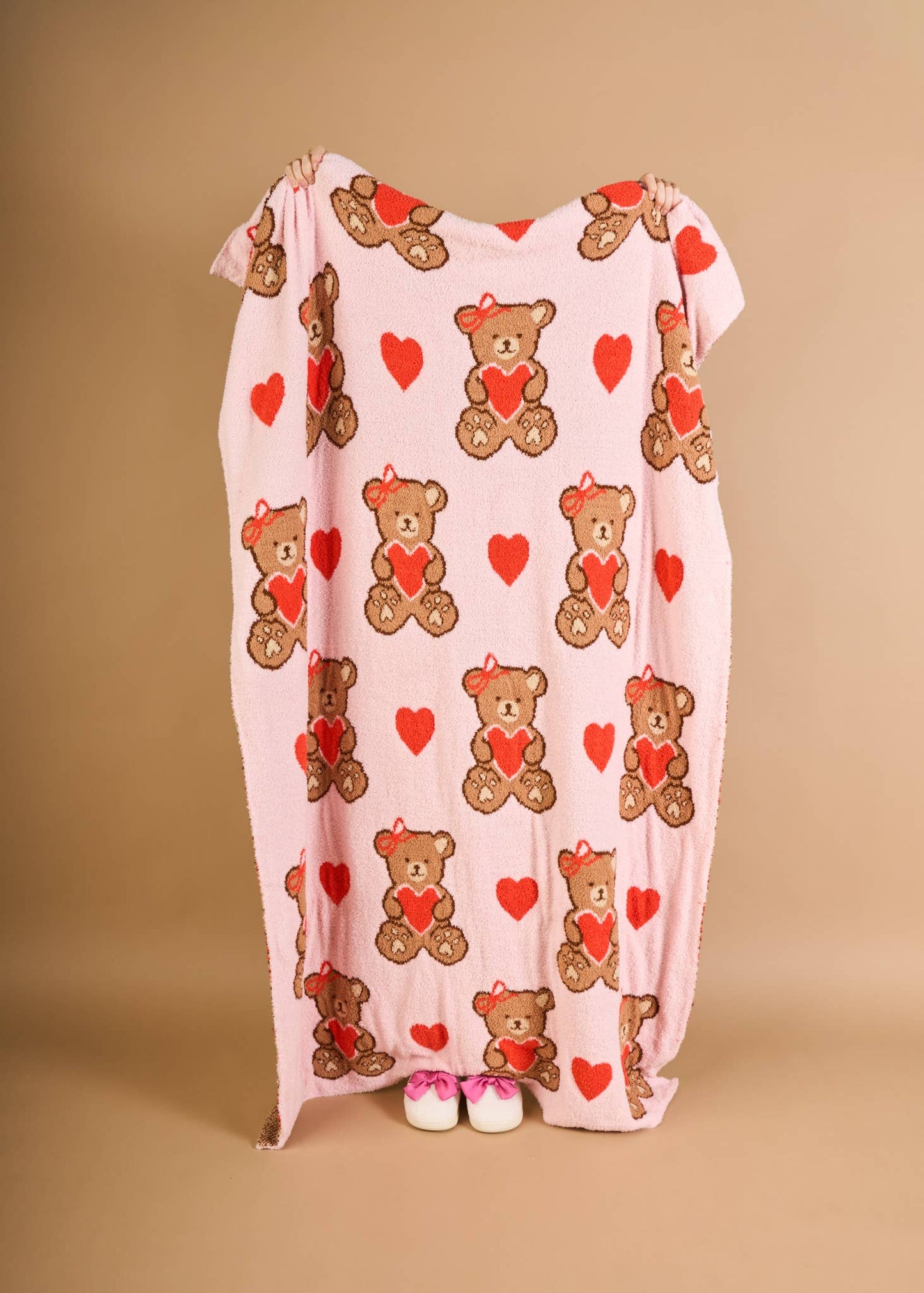Cozy pink blanket featuring cute teddy bears and hearts, perfect for kids.