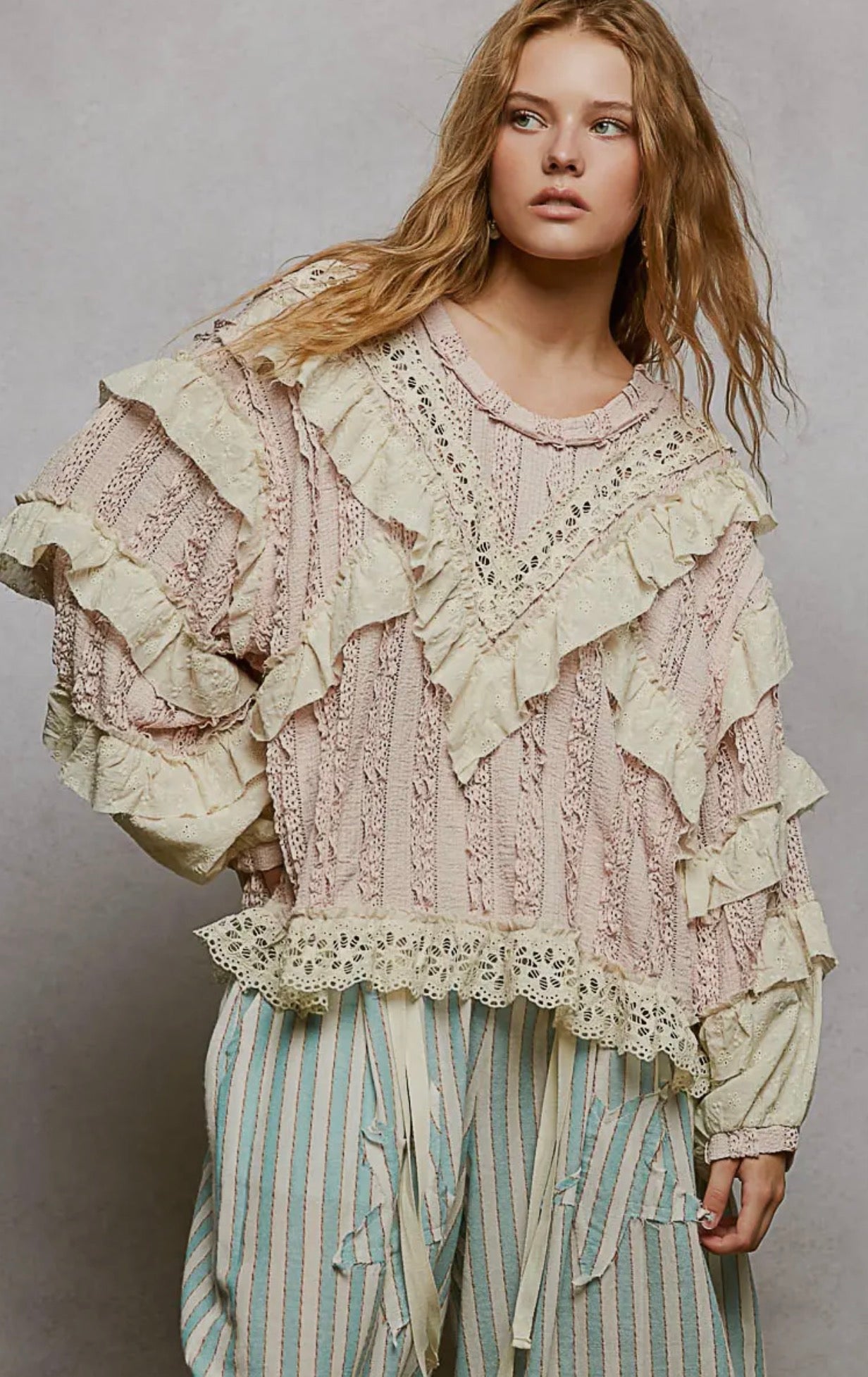 Pink knitted sweater with lace detailing and ruffles for a stylish boho look.
