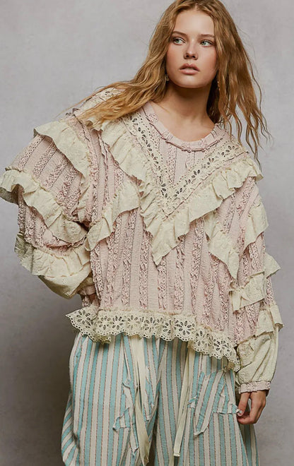 Pink knitted sweater with lace detailing and ruffles for a stylish boho look.