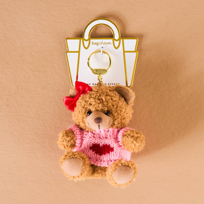 Cute brown bear keychain with red bow and pink sweater, perfect accessory for bags.