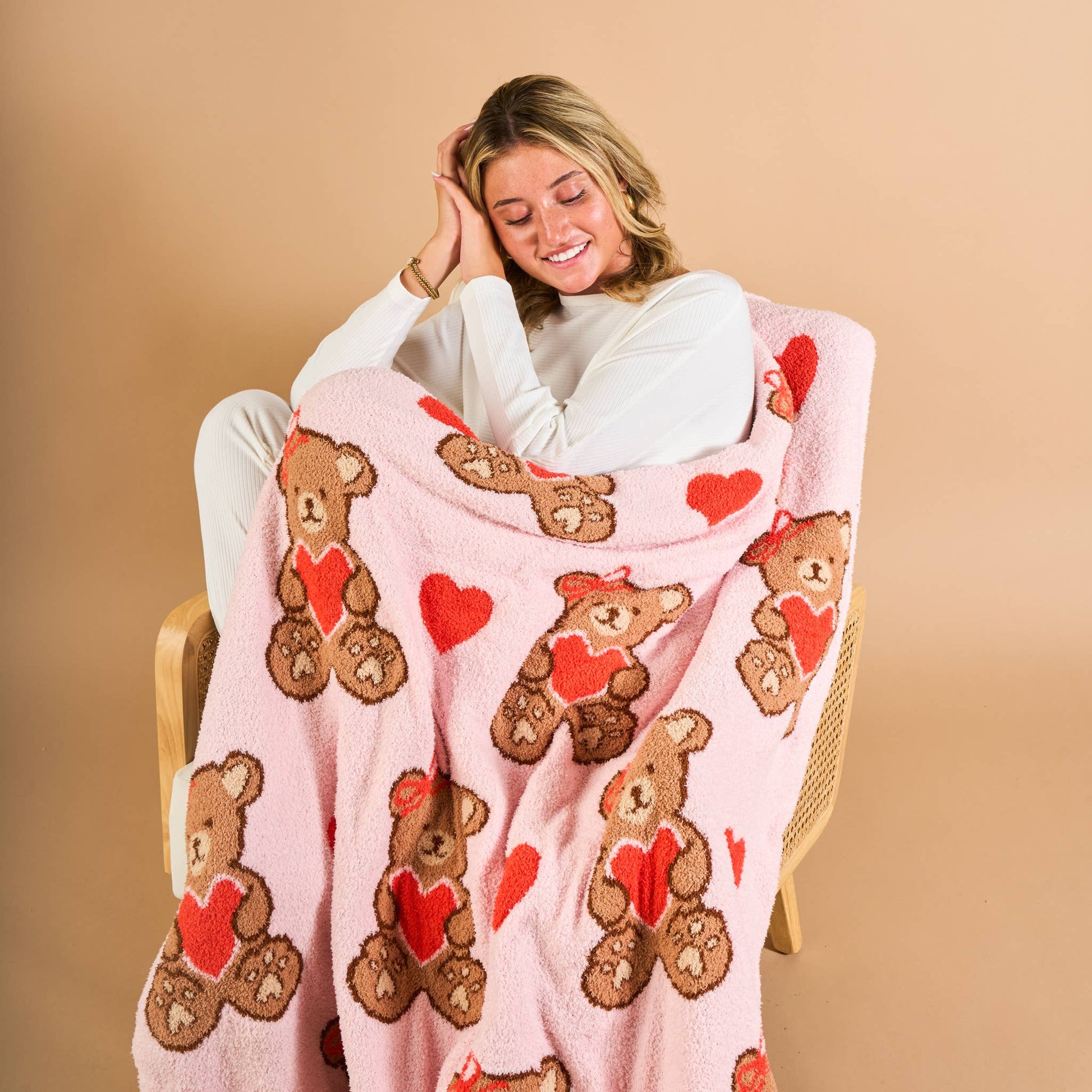 Cozy pink fleece blanket featuring cute bears and hearts, perfect for snuggling and adding warmth.